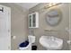 Cozy bathroom features a toilet, sink with a pedestal, a round mirror, and a white cabinet at 1875 Edgemont Ct, Cumming, GA 30041