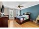 Charming bedroom featuring hardwood floors, a ceiling fan and a blue accent wall at 1875 Edgemont Ct, Cumming, GA 30041