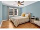Bedroom featuring hardwood floors, a ceiling fan and light blue walls at 1875 Edgemont Ct, Cumming, GA 30041