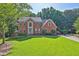 Charming brick two-story home featuring a well-manicured lawn and mature trees at 1875 Edgemont Ct, Cumming, GA 30041