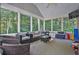 A screened porch with wicker furniture provides extra space to relax at 1875 Edgemont Ct, Cumming, GA 30041
