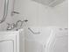 This bathroom features a walk-in tub and shower with modern fixtures, safety grab bar, and bright white walls at 3119 Medley Rdg, Decatur, GA 30033