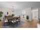 Bright dining room seamlessly connecting to the kitchen, featuring elegant light fixture and wood floors at 3119 Medley Rdg, Decatur, GA 30033