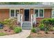 Close-up view of a charming front porch with well-maintained landscaping and a classic brick facade at 3119 Medley Rdg, Decatur, GA 30033