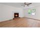 Bright living room with a charming fireplace, ceiling fan, and natural light from a large window at 3119 Medley Rdg, Decatur, GA 30033