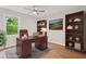 The staged office boasts a large window, a traditional desk, hardwood floors, and attractive shelving at 3119 Medley Rdg, Decatur, GA 30033