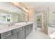 Modern bathroom with double vanity, large mirror, walk-in shower, and luxurious soaking tub at 4525 Aiden Way, Cumming, GA 30041