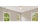Bedroom featuring neutral colors, carpet, and three windows with natural light and wooded views at 4525 Aiden Way, Cumming, GA 30041