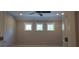 Bright bedroom with three windows and a modern ceiling fan at 4525 Aiden Way, Cumming, GA 30041
