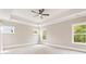 Spacious bedroom with tray ceiling, ceiling fan, multiple windows, and neutral colored carpet at 4525 Aiden Way, Cumming, GA 30041