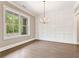 Dining room with hardwood floors, white trim, wainscotting, and a modern chandelier at 4525 Aiden Way, Cumming, GA 30041