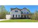 Beautiful two-story modern farmhouse with white siding, black trim, and a well-manicured lawn at 4525 Aiden Way, Cumming, GA 30041