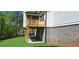 Exterior view of a home featuring a raised wood deck, brick siding, green lawn, and mature trees at 4525 Aiden Way, Cumming, GA 30041