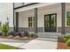 Covered front porch featuring brick base, black support columns, and a double front door with glass inserts at 4525 Aiden Way, Cumming, GA 30041