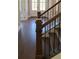 A staircase with dark wood floors and metal spindles leads to a bright entryway with glass doors at 4525 Aiden Way, Cumming, GA 30041