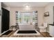 This bathroom features a modern soaking tub under a picture window and a black-and-white decorative color scheme at 573 Hastings Way, Jonesboro, GA 30238