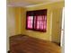 Bedroom with wood flooring, natural light, and a sheer red curtain at 127 Perry St, Loganville, GA 30052
