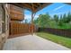 View of the back patio with wooden fence, green lawn, and wooden deck above, perfect for outdoor living at 1858 Glenview Park Cir, Duluth, GA 30097