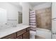 Well-lit bathroom featuring a shower-tub combo with tiled walls and a modern vanity at 1858 Glenview Park Cir, Duluth, GA 30097