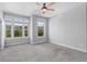 Bright bedroom with three windows and gray carpet, illuminated by a modern ceiling fan at 1858 Glenview Park Cir, Duluth, GA 30097