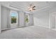 Spacious primary bedroom featuring a ceiling fan, carpeted floor and large windows at 1858 Glenview Park Cir, Duluth, GA 30097