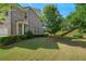 Beautifully landscaped front yard with lush green lawn, a young tree, and a stylish brick facade at 1858 Glenview Park Cir, Duluth, GA 30097