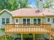 Exterior view of house with back deck, windows and large yard with lush trees at 2930 Heather Stone Way, Lawrenceville, GA 30043