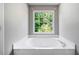 Bright bathtub with a large window at 2930 Heather Stone Way, Lawrenceville, GA 30043