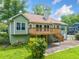 Back exterior of home featuring an elevated deck and lush backyard at 2930 Heather Stone Way, Lawrenceville, GA 30043