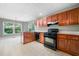 Well-lit kitchen offering black appliances, wooden cabinets, and natural light at 2930 Heather Stone Way, Lawrenceville, GA 30043