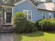 Close-up of a quaint single-Gathering home, with blue siding, surrounded by neatly trimmed bushes and a small lawn at 4059 Heritage Valley Ct, Norcross, GA 30093