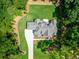 Aerial view of the new construction home with landscaped yard and long driveway surrounded by mature trees at 410 Iroquois Ct, Covington, GA 30014
