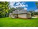 Side view of a charming new construction home with a well-manicured lawn and wooded backdrop at 410 Iroquois Ct, Covington, GA 30014