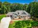 An aerial view of a well-manicured lawn, a spacious driveway, and a charming facade enhanced by surrounding lush greenery at 410 Iroquois Ct, Covington, GA 30014