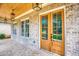 Elegant double front doors with glass panels, brick facade, and lantern-style pendant lighting on the covered porch at 410 Iroquois Ct, Covington, GA 30014
