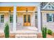 Inviting front porch with brick flooring, natural wood double front doors, and lantern-style pendant lighting at 410 Iroquois Ct, Covington, GA 30014