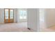 An open living space featuring double doors, large windows, and unfinished flooring, awaiting your personal touch at 410 Iroquois Ct, Covington, GA 30014