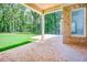 Covered brick patio overlooking a spacious yard with lush trees at 410 Iroquois Ct, Covington, GA 30014