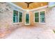 Relaxing covered patio with exposed brick, wood ceilings, and views of the surrounding greenery at 410 Iroquois Ct, Covington, GA 30014