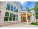 Stunning rear exterior with a brick facade, large windows, and a covered patio at 410 Iroquois Ct, Covington, GA 30014