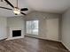 Bright living room with fireplace, wood floors, ceiling fan, and vaulted ceiling at 155 Fairclift Dr, Covington, GA 30016
