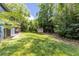 Serene backyard features a storage shed and mature trees, offering a private outdoor retreat at 178 Castleair Ne Dr, Kennesaw, GA 30144