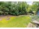 Scenic backyard view featuring a fire pit, lush lawn, and mature trees with a storage shed at 178 Castleair Ne Dr, Kennesaw, GA 30144