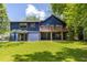 Back exterior view features spacious deck, lush lawn, and mature trees with a storage shed at 178 Castleair Ne Dr, Kennesaw, GA 30144