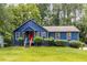 Charming blue home with a red front door and a lush green lawn and mature shade trees at 178 Castleair Ne Dr, Kennesaw, GA 30144