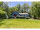 Charming blue house with a bright red door, surrounded by a lush green lawn and mature trees at 178 Castleair Ne Dr, Kennesaw, GA 30144