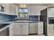 Well-lit kitchen features white cabinets, a stainless steel dishwasher, and a stainless refrigerator at 178 Castleair Ne Dr, Kennesaw, GA 30144
