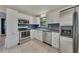 Updated kitchen features white cabinets, stainless steel appliances, tile floors and plenty of storage at 178 Castleair Ne Dr, Kennesaw, GA 30144