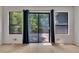 Living room featuring hardwood floors, bright windows, blue curtains and sliding glass door to the outdoor deck at 178 Castleair Ne Dr, Kennesaw, GA 30144