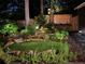 Backyard featuring a rock waterfall, manicured lawn, landscape lighting, and a wooden fence at 1833 N Rock Springs Ne Rd, Atlanta, GA 30324